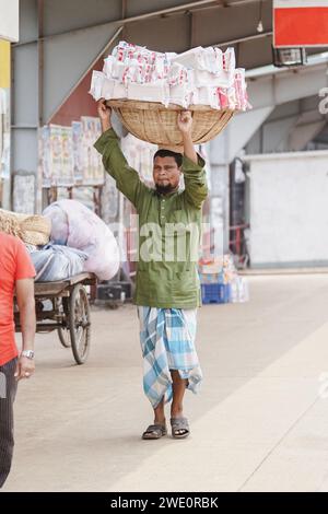 Mann aus Bangladesch mit einem Korb Brot auf dem Kopf im Startterminal von Sadarghat (Sadarghat, Dhaka, Bangladesch 09-05-2023) Stockfoto