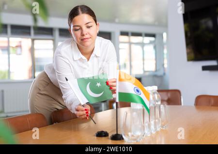 Die junge Dame legt für internationale Verhandlungen Miniaturflaggen von Indien und Pakistan an Stockfoto