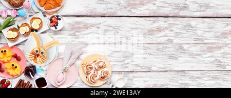 Osterfrühstück oder Brunch an der Ecke. Blick von oben auf weißem Holzhintergrund. Hasenpfannkuchen, Eiernester, Hühnerfrüchte und verschiedene Frühlingsfuttersorten Stockfoto