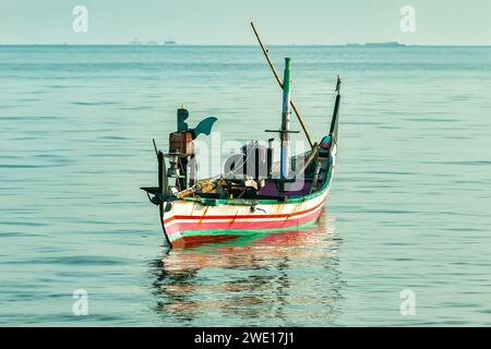 Fischerboot segelt auf dem riesigen blauen Ozean unter klarem Himmel Stockfoto