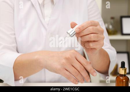 Dermatologe testet kosmetisches Produkt an Tisch drinnen, Nahaufnahme Stockfoto