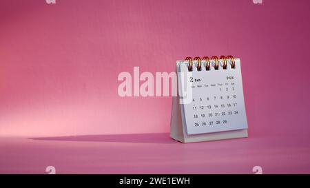 Schreibtischkalender für Februar 2024 auf rosafarbenem Hintergrund mit Kopierraum. Stockfoto