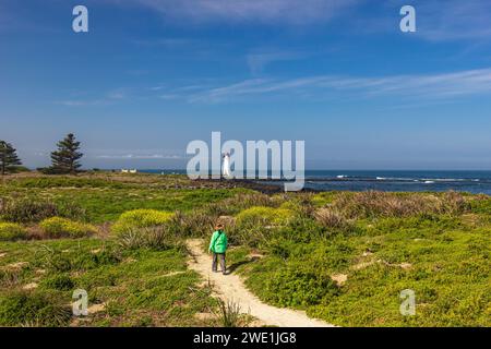 Gewundener Wanderweg durch Strauchvegetation mit Port Fairy Lighthouse im Hintergrund auf Griffiths Island of Port Fairy in Victoria, Australien. Stockfoto