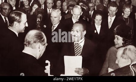 Martin Luther King Jr., Gewinner des Friedensnobelpreises 1964, wurde am 10. Dezember 1964 von seiner Königlichen Hoheit Kronprinz Harold (links) und seiner Majestät König Olav V. (zurück zur Kamera) in Oslo, Norwegen, herzlich gratuliert. Dr. King wird von seiner Frau Coretta zu seiner Linken begleitet. Stockfoto