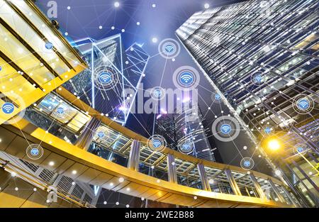 Intelligente Stadt und drahtloses Kommunikationsnetzwerk auf Wolkenkratzern im zentralen Hongkong Hintergrund, modernes Finanztechnologiekonzept. Stockfoto