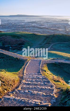 Winter Sonnenaufgang Licht über den British Camp Hill Fort Steps entlang der Malvern Hills, Worcestershire, England Stockfoto