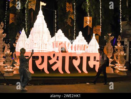 Mumbai, Indien. Januar 2024. A Woman (L) nimmt ein Video der RAM-Tempelinstallation auf, die mit Lichtern vor der Residenz des indischen Geschäftsmannes Mukesh Ambani in Mumbai dekoriert ist. Die Straße wurde dekoriert, um der Weihungszeremonie des Hindugottes Lord RAM in Ayodhya im Bundesstaat Uttar Pradesh zu gedenken. Quelle: SOPA Images Limited/Alamy Live News Stockfoto