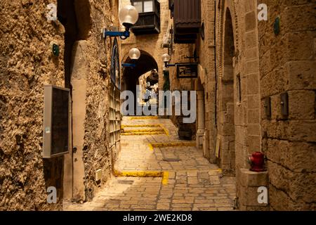 Eine enge Gasse mit gelb bemalten Stufen und historischer Steinarchitektur in Jaffa, Israel. Stockfoto