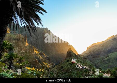Ein spektakulärer Blick auf die Sonne hinter den Bergen, die ein warmes Leuchten über das malerische Masca-Tal auf Teneriffa wirft. Stockfoto