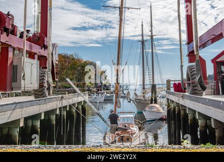 Entfernen Eines Segelbootmastes der Mast wird von einem kleinen Segelboot an einem New England Service Dock abgenommen, bevor das Boot aus dem Wasser gehoben wird. Stockfoto