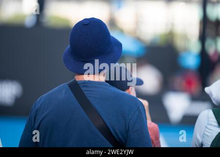 Touristen mit Rucksäcken in einer Menge, die ein Sportereignis in einem Stadion beobachtet. Sportfans jubeln und beobachten Tennis bei den Australian Open in Australien Stockfoto