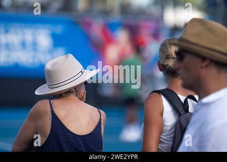 Touristen mit Rucksäcken in einer Menge, die ein Sportereignis in einem Stadion beobachtet. Sportfans jubeln und beobachten Tennis bei den Australian Open in Australien Stockfoto