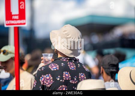 Touristen mit Rucksäcken in einer Menge, die ein Sportereignis in einem Stadion beobachtet. Sportfans jubeln und beobachten Tennis bei den Australian Open in Australien Stockfoto