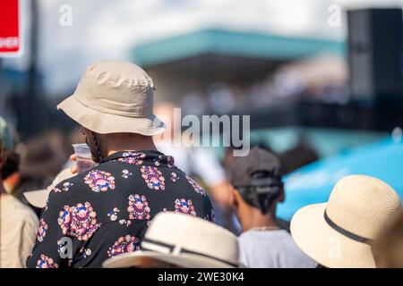 Touristen mit Rucksäcken in einer Menge, die ein Sportereignis in einem Stadion beobachtet. Sportfans jubeln und beobachten Tennis bei den Australian Open in Australien Stockfoto