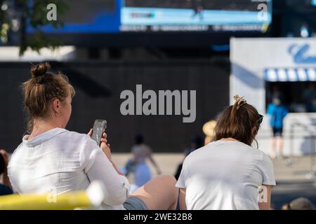 Touristen mit Rucksäcken in einer Menge, die ein Sportereignis in einem Stadion beobachtet. Sportfans jubeln und beobachten Tennis bei den Australian Open in Australien Stockfoto