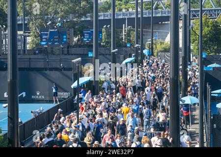 Touristen mit Rucksäcken in einer Menge, die ein Sportereignis in einem Stadion beobachtet. Sportfans jubeln und beobachten Tennis bei den Australian Open in Australien Stockfoto