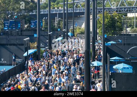 Touristen mit Rucksäcken in einer Menge, die ein Sportereignis in einem Stadion beobachtet. Sportfans jubeln und beobachten Tennis bei den Australian Open in Australien Stockfoto