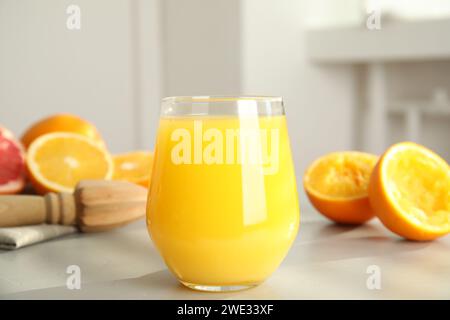 Frisch zubereiteter Saft, Orangen und Reibahle auf dem Tisch, Nahaufnahme Stockfoto