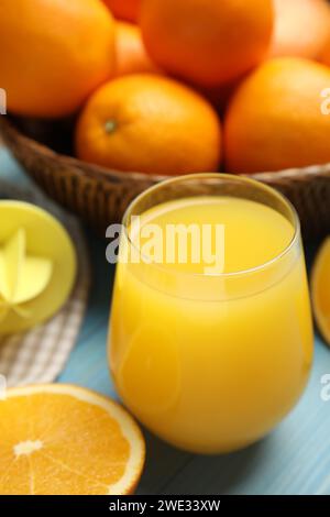 Frisch zubereiteter Saft, Orangen und Reibahle auf blauem Tisch Stockfoto