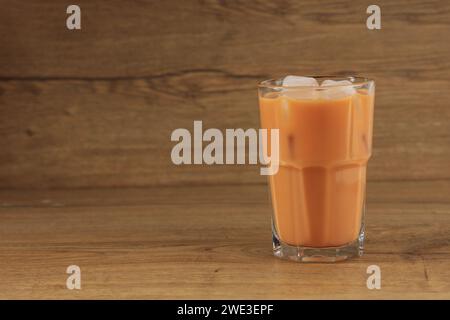 Ein Glas Eis Thai Milch Tee Cha Yen auf Holztisch, Kopierraum für Text Stockfoto