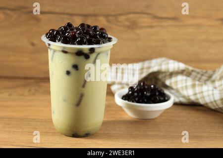 Matcha Green Tea Milk Latte mit Boba Bubble Tapioka Perle, auf Holztisch Stockfoto