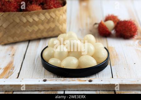 Geschälter Rambutan auf Keramikplatte auf Holztisch Stockfoto