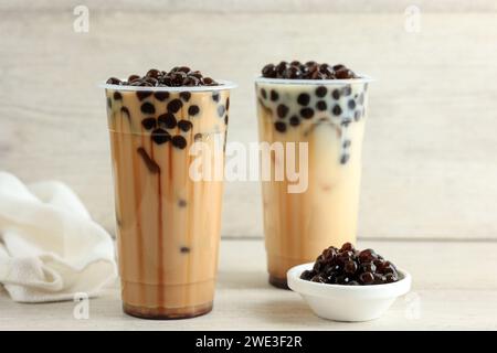 Taiwan Milchtee mit Boba Luftpolsterperle auf Kunststoff Einwegbecher, auf hölzernem Hintergrund Stockfoto