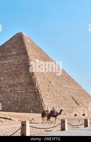 Gizeh, Ägypten - 24. Dezember 2023: Die große Pyramide Khufu (Cheops-Pyramide) ist die älteste und größte der drei Pyramiden und Kamele in Gizeh Stockfoto