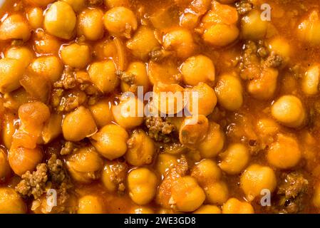 Kichererbseneintopf mit Hackfleisch auf einem weißen Porzellanteller auf einem Steintisch Stockfoto