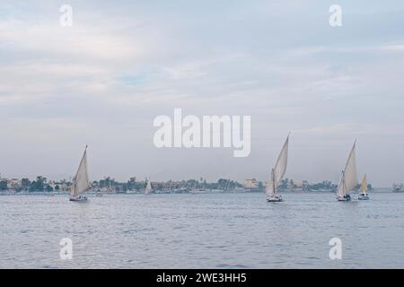 Luxor, Ägypten - 26. Dezember 2023: Traditionelle Feluken segeln am Morgen auf dem Nil Stockfoto