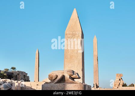 Luxor, Ägypten - 26. Dezember 2023: Statue von Khepri, dem heiligen Scarab mit Obelisken im Tempelkomplex Karnak Stockfoto