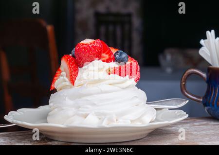 Nachtisch auf Meringue-Basis. Mini Pavlova mit Erdbeere und Heidelbeere. Weichzeichner. Selektiver Fokus. Stockfoto