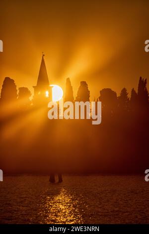 Der Glockenturm des Klosters San Michele del Deserto, der bei Sonnenaufgang aus dem Nebel auftaucht. Burano, Venedig, Italien Stockfoto