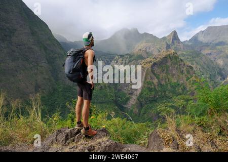 Der Wanderer betrachtet die Berge des Kreises von Mafate auf der Insel Reunion. Die tropische Insel ist beliebt für Wanderungen im Freien und Wanderwege. Stockfoto