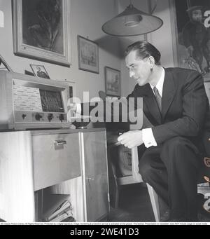 Radio in den 1940ern Ein gut gekleideter Mann in seinem Haus wird gesehen, wie er Radio hört. Er ist Lauritz Falk, 1909-1990, Schwedisch-norwegischer Schauspieler. 1946. Kristoffersson Ref. T63-5 Stockfoto