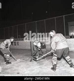 Eishockey in den 1950ern Ein Torhüter und zwei Spieler auf der Eishockeybahn. 1959. Kristoffersson Ref. CL20-3 Stockfoto