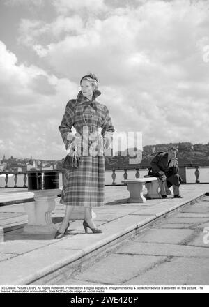 Modisch in den 1950er Jahren Eine junge Frau trägt einen typischen Mantel aus den 1950er Jahren. Eine Hutschachtel von Hutmachern Cavanagh Hats, Park Avenue, New York, ist auf dem Bild zu sehen. 1950. Ref. I813 Stockfoto