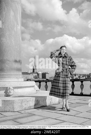 Modisch in den 1950er Jahren Eine junge Frau trägt einen typischen Mantel aus den 1950er Jahren. Eine Hutschachtel von Hutmachern Cavanagh Hats, Park Avenue, New York, ist auf dem Bild zu sehen. 1950. Ref. I813 Stockfoto