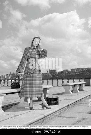 Modisch in den 1950er Jahren Eine junge Frau trägt einen typischen Mantel aus den 1950er Jahren. Eine Hutschachtel von Hutmachern Cavanagh Hats, Park Avenue, New York, ist auf dem Bild zu sehen. 1950. Ref. I815 Stockfoto