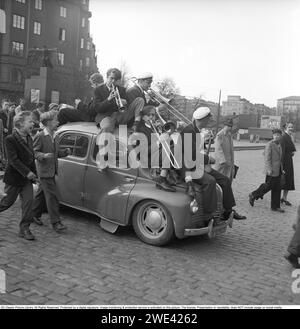 Die Studentenfeier 1954. Die Studenten feiern ihre abgeschlossene Immatrikulation und eine Band sitzt auf einem Renault 4CV, der unter dem Gewicht des Orchesters stark absackt. Sie passieren das Fliegerdenkmal in Karlaplan in Stockholm. Schweden 1954. Svahn Ref. SVA2 Stockfoto
