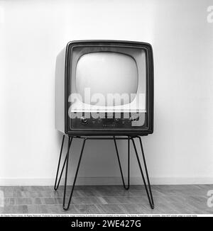 Fernsehgerät in den 1950ern Ein frühes Fernsehgerät von Philips im historischen Design und auf einem Ständer aus Metallbeinen, das nur Fernsehsendungen in Schwarzweiß wiedergeben kann. Mit den Knöpfen an der Vorderseite steuern Sie Bild und Ton. 1956 Svahn Ref. SVA2 Stockfoto