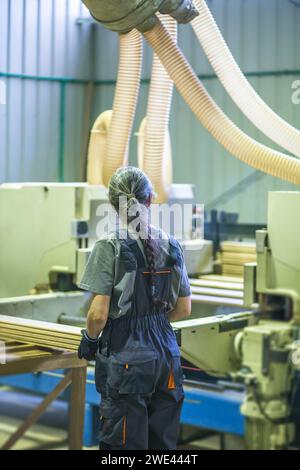 Arbeitnehmerin mit Dielen in der Holzverarbeitungsfabrik Stockfoto