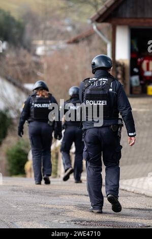 Unterkirnach, Deutschland. Januar 2024. Polizisten laufen mit voller Ausrüstung durch ein Wohngebiet. Da eine Räumung zu eskalieren drohte, entsendet die Polizei derzeit ein großes Kontingent. Quelle: Silas Stein/dpa/Alamy Live News Stockfoto