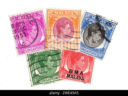 Vintage-Briefmarken aus Malaya mit einem Porträt von König Georg VI. Auf weißem Hintergrund. Stockfoto
