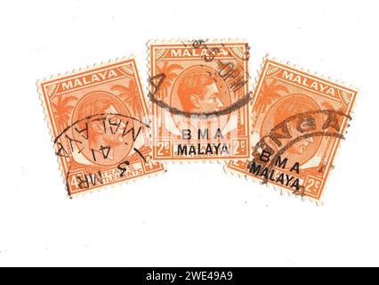 Orangene Vintage-Briefmarken aus Malaya mit einem Porträt von König Georg VI. Auf weißem Hintergrund. Stockfoto