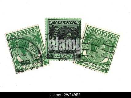 Grüne Vintage-Briefmarken aus Malaya mit einem Porträt von König Georg VI. Auf weißem Hintergrund. Stockfoto
