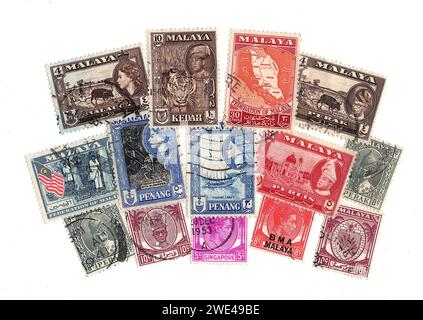 Alte Briefmarken aus Malaya, isoliert auf weißem Hintergrund. Stockfoto