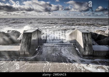 Wellen kommen über die Seeschützung in Rossall, Lancashire, Großbritannien Stockfoto