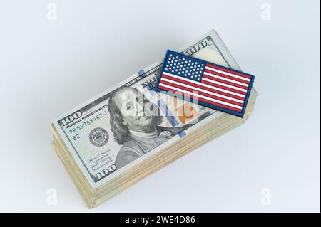 100-Dollar-Schatzstapel mit amerikanischem Flaggenaufkleber drauf Stockfoto