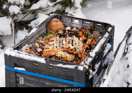 Offene Kompostkiste mit Bioabfall innen, draußen im Winter, schneebedecktes kaltes Wetter. Stockfoto
